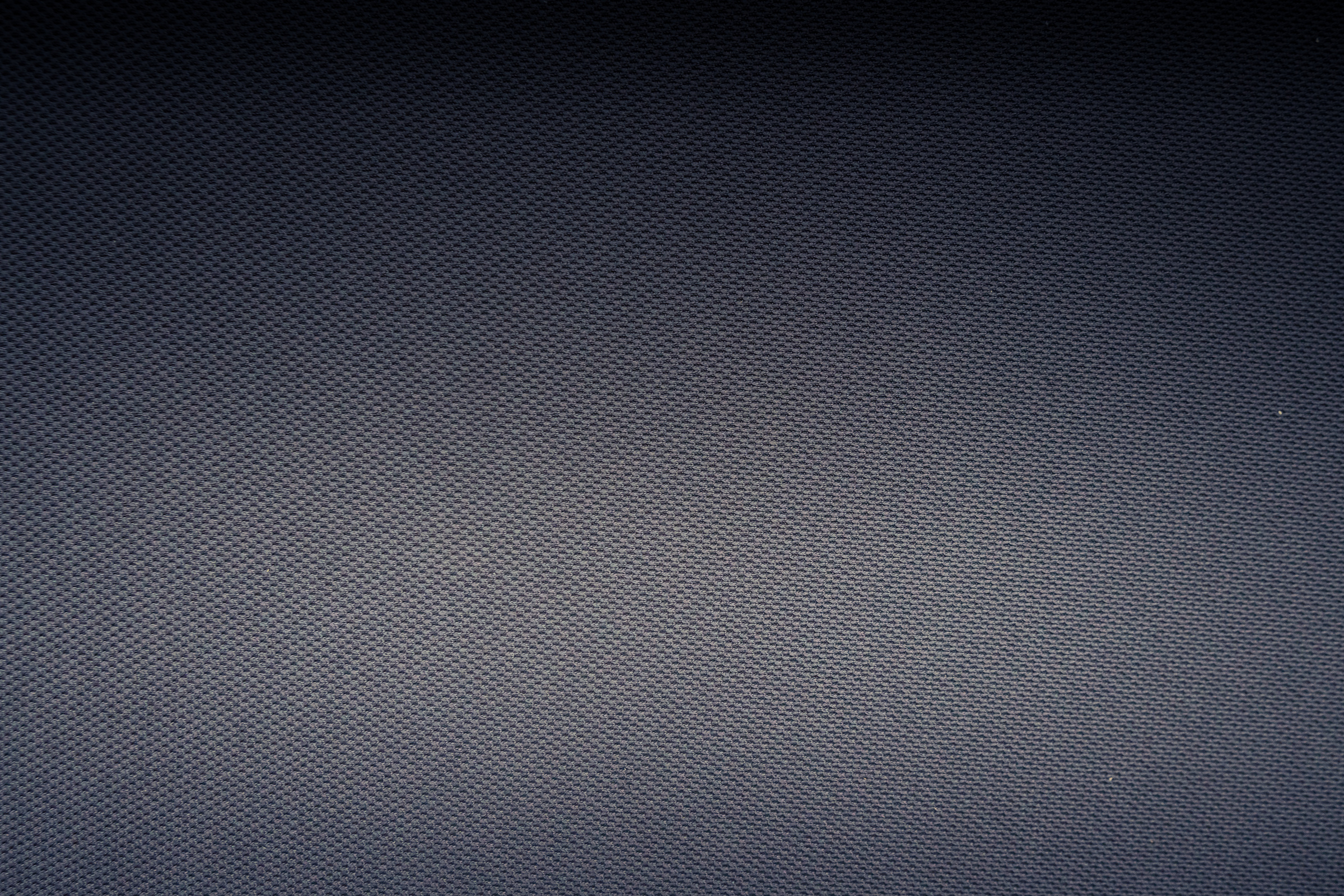 Textured background of carbon fiber fabric with tiny holes