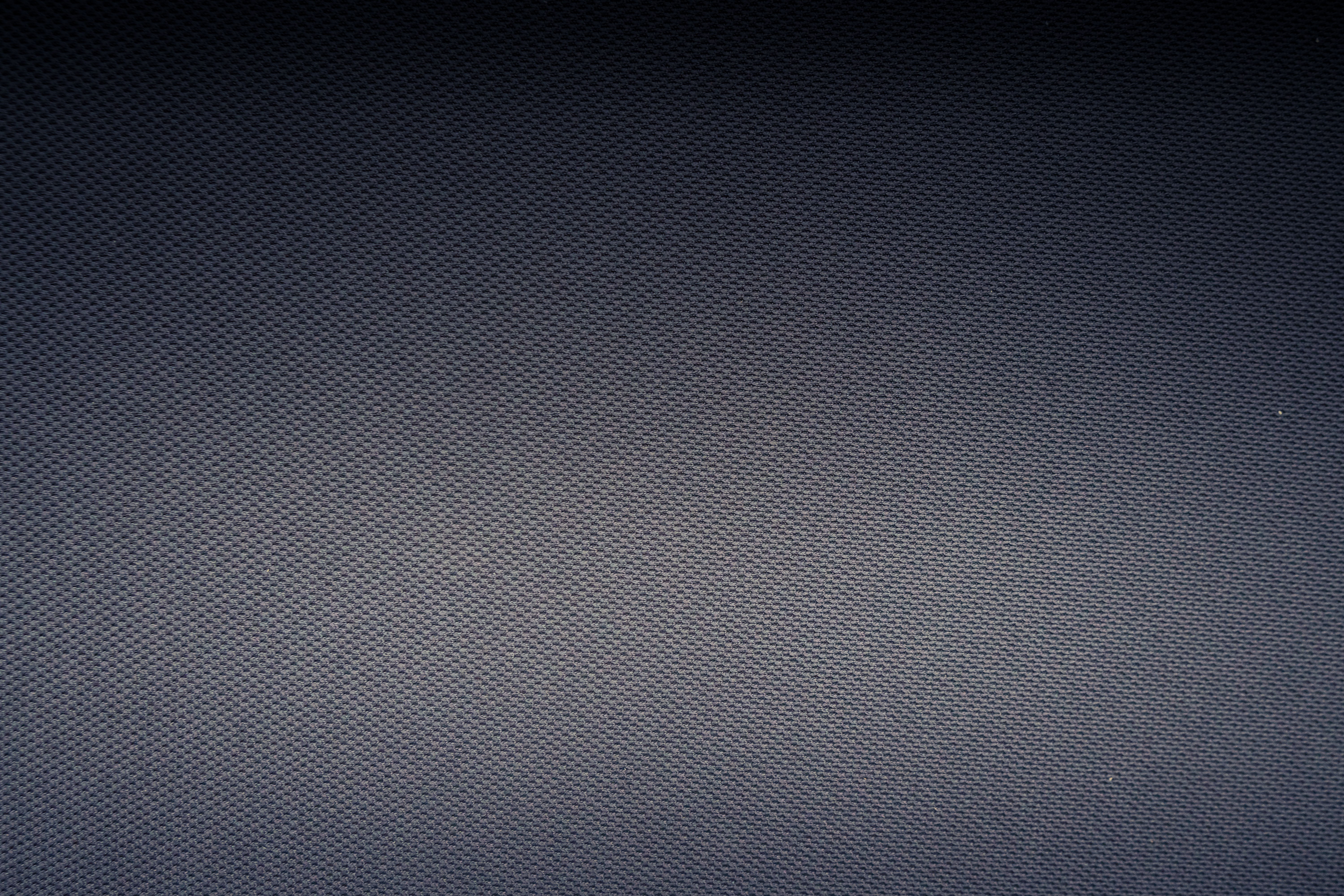 Textured background of carbon fiber fabric with tiny holes